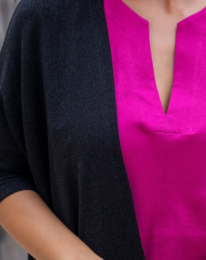Person wearing a black and pink outfit with a deep neckline.
