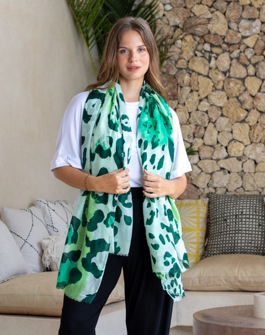 Woman wearing a green leopard print scarf in a living room setting
