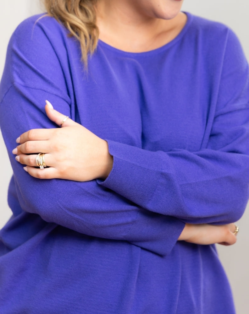 Person wearing a violet tunic knit with ribbed sleeves