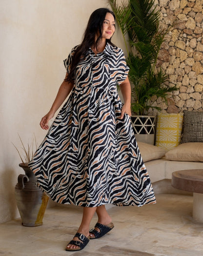 Woman wearing a zebra print dress in a cozy living room setting.