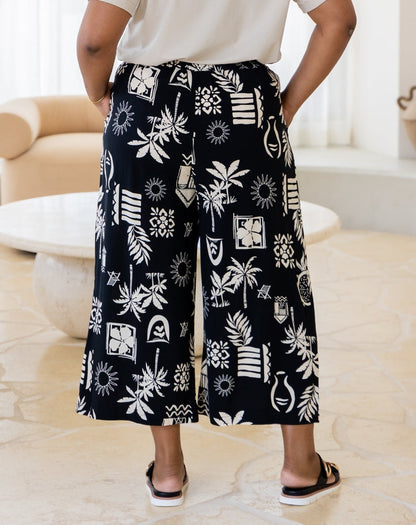 Person wearing black and white patterned pants in a living room setting