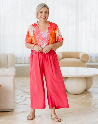 Woman wearing a colorful outfit in a living room setting