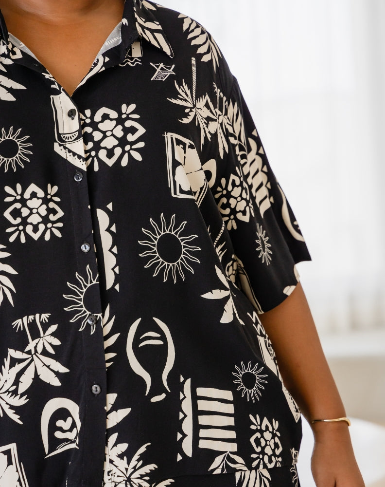 Black shirt with white abstract patterns worn by a person