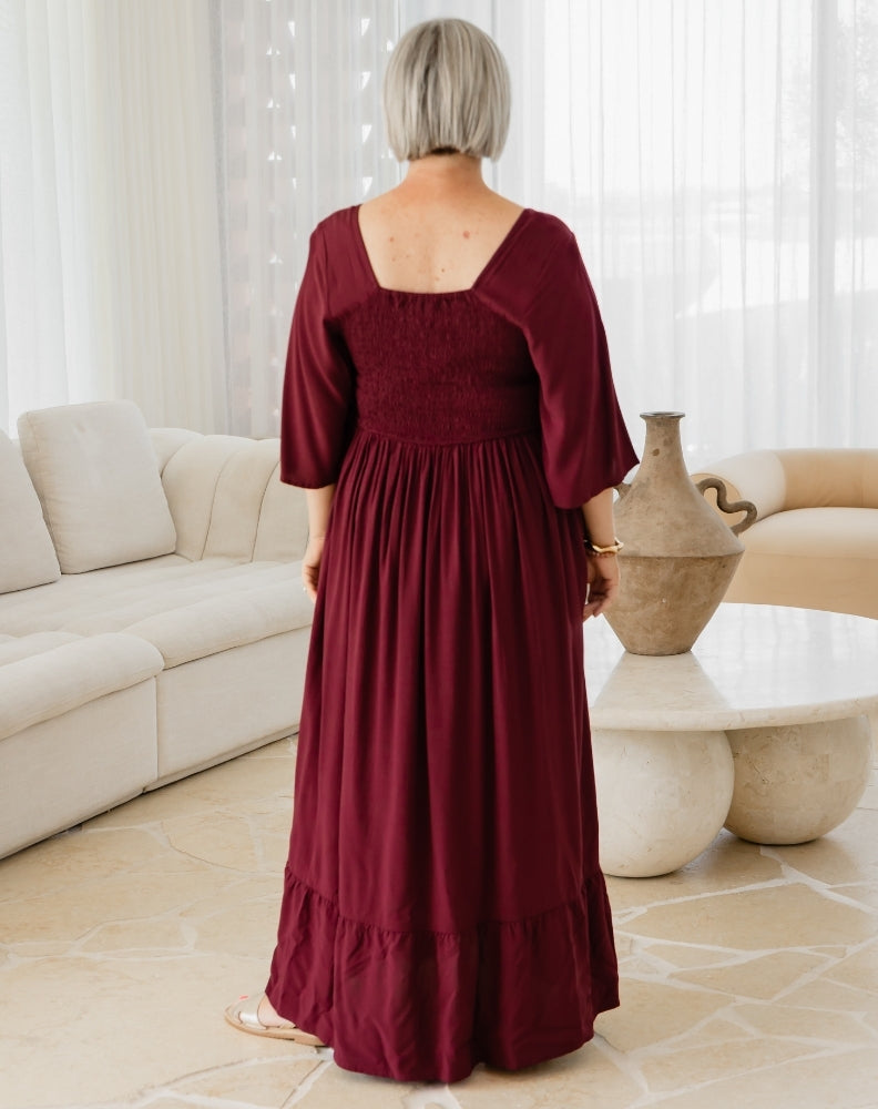 Person wearing a burgundy dress in a living room setting