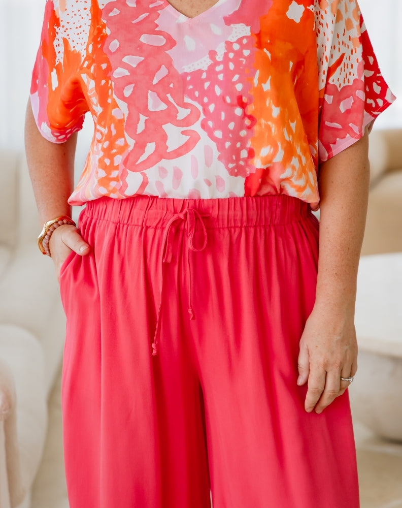 Person wearing a colorful top with a white background