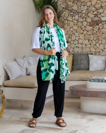 Woman wearing a green patterned scarf in a living room setting