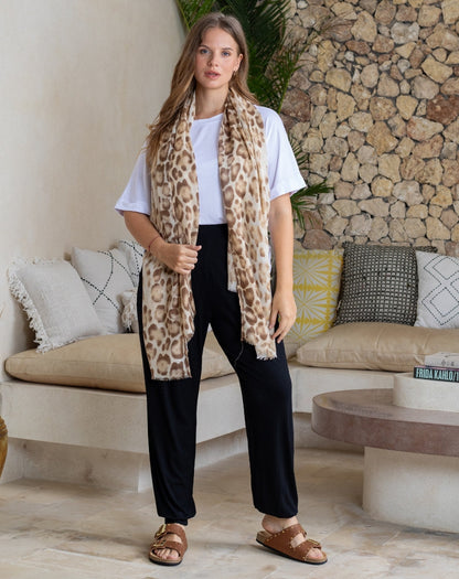 Woman wearing a leopard print scarf in a living room setting